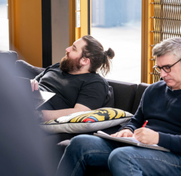 2 men working and discussing in a couch