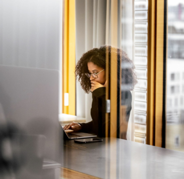 Woman thinking in front of her laptop