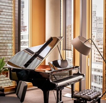Un piano dans une pièce aevc de belles fenêtres