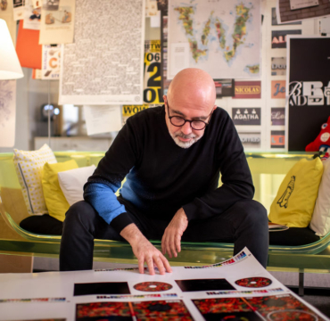 Un homme assis sur un canapé regardant une planche de visuels