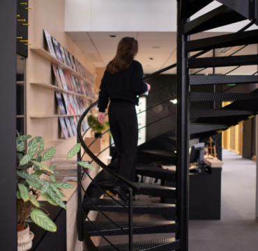 Femme qui monte un escalier en colimaçon dans une entreprise