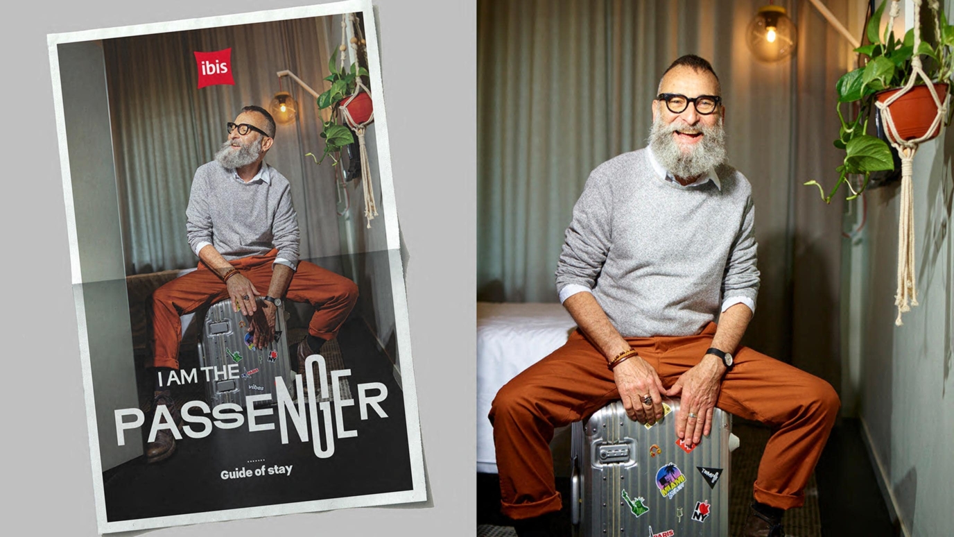 Un homme souriant assis sur une valise