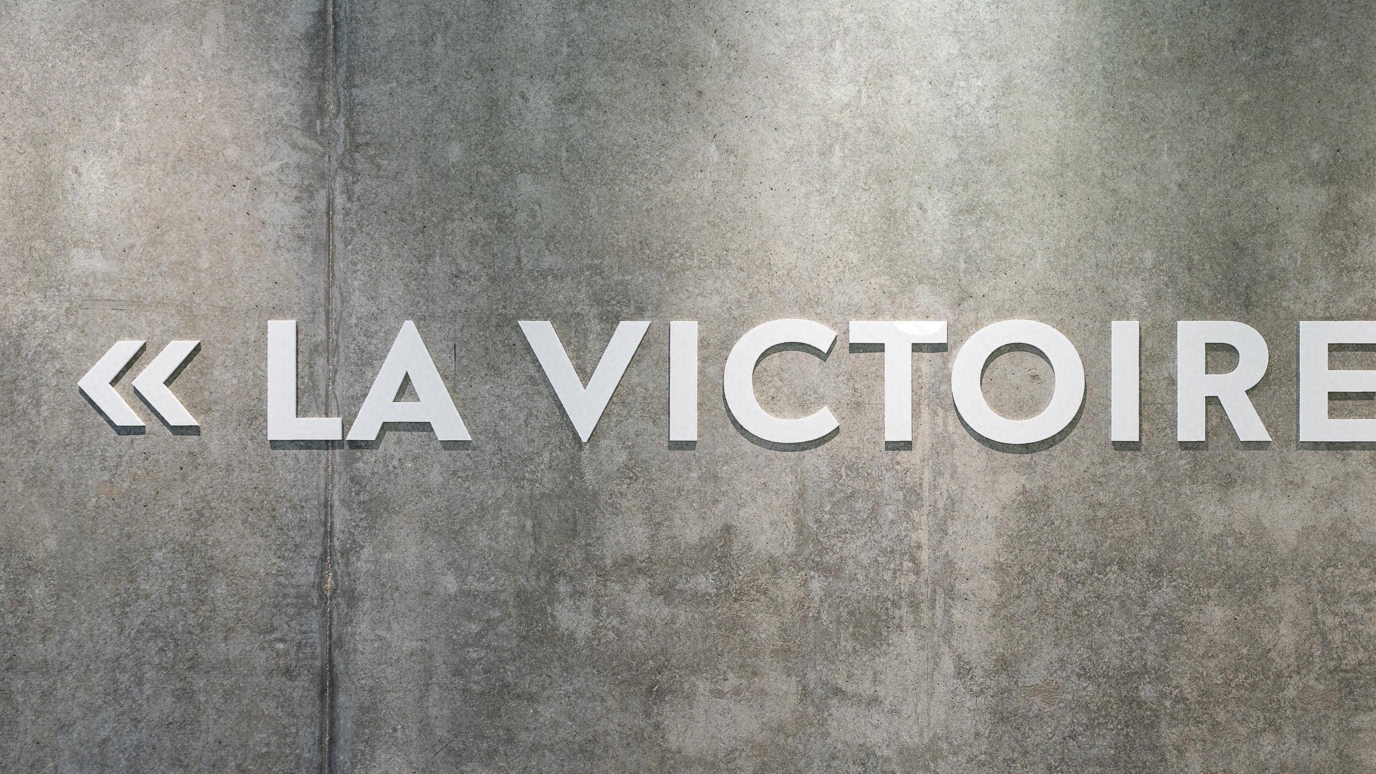 Texte " LA VICTOIRE3 sur un mur gris