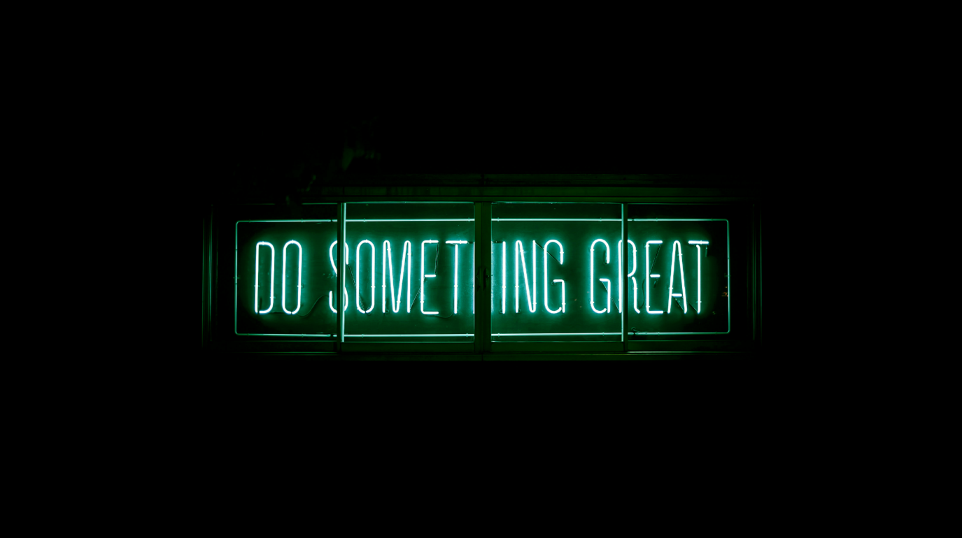 Texte neon verre "do something great" sur fond noir