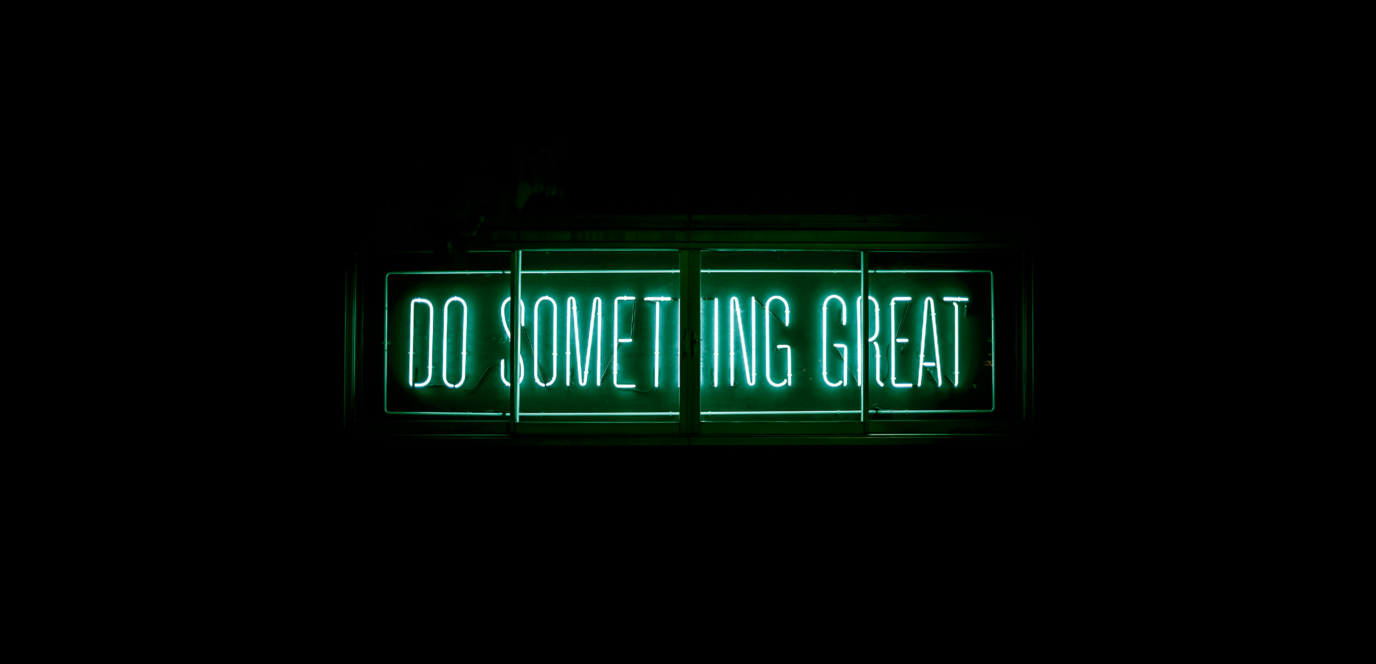 Texte neon verre "do something great" sur fond noir